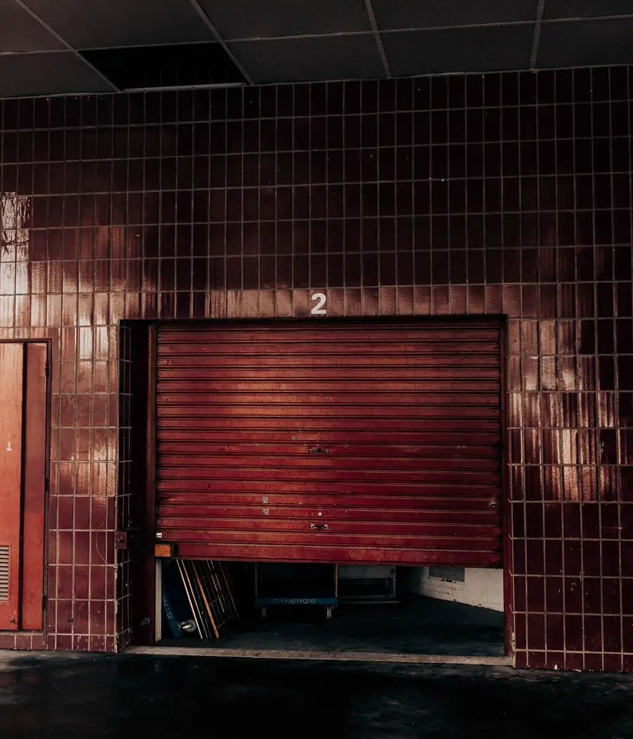Red rolling steel door in a tiled garage entrance